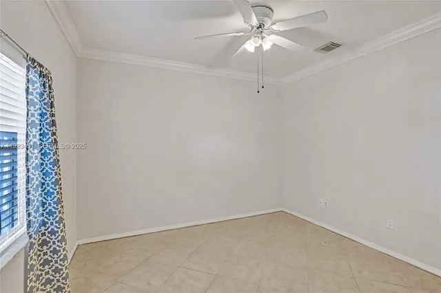 an empty room with a window and a ceiling fan