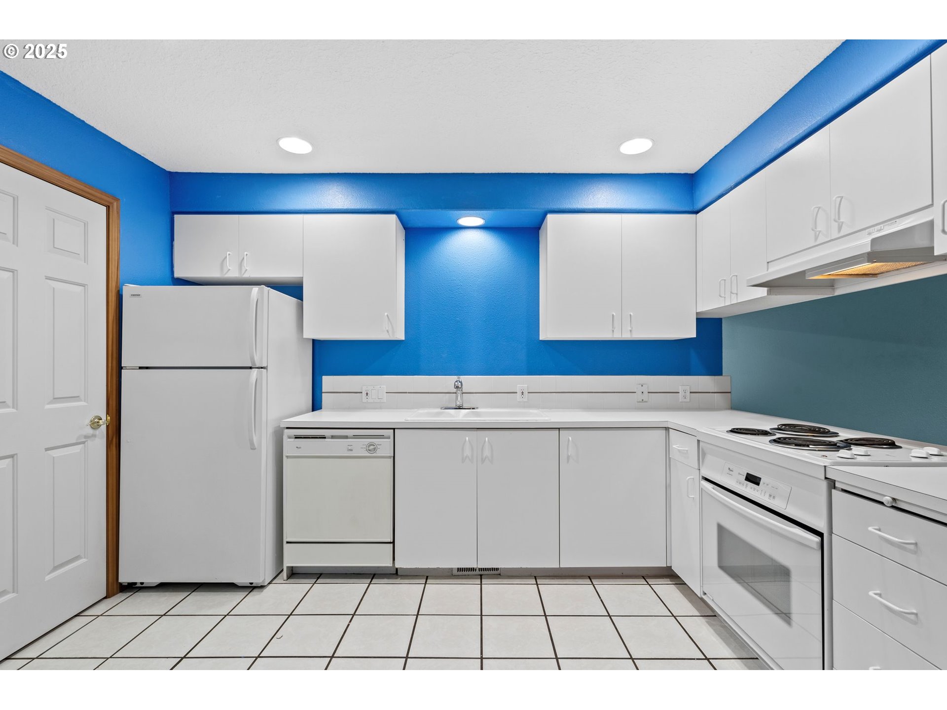 14134 East Burnside Street, Unit 2 Portland, OR 97233 - Photo 15 of 37 a kitchen with a stove a refrigerator and white cabinets