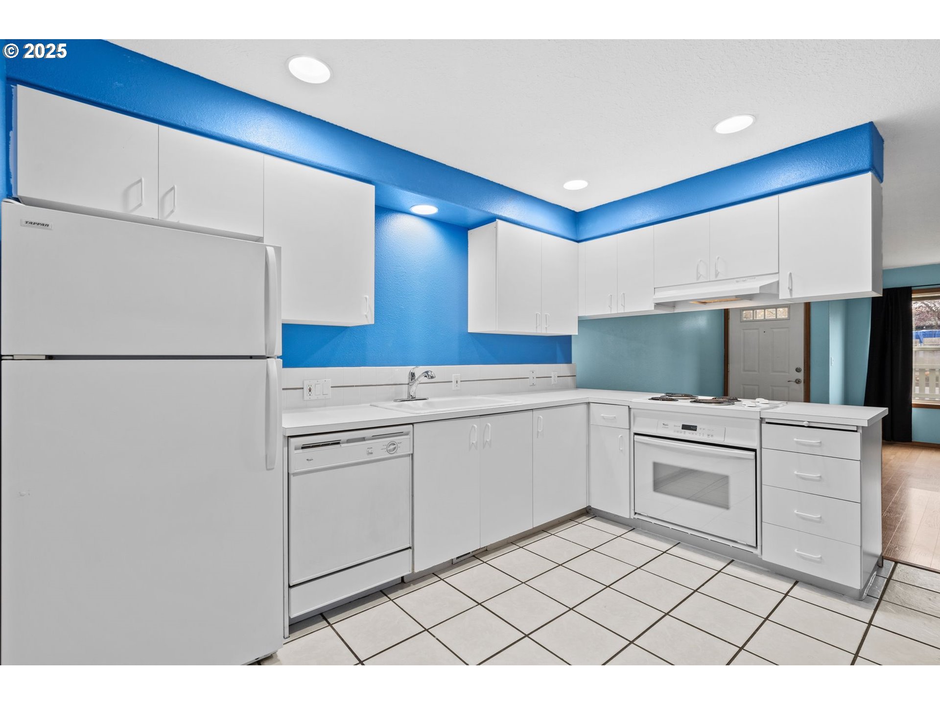 14134 East Burnside Street, Unit 2 Portland, OR 97233 - Photo 16 of 37 a kitchen with white cabinets and white appliances