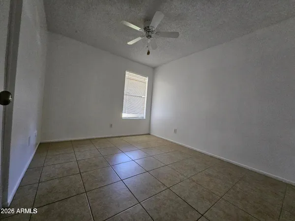 an empty room with a ceiling fan and window