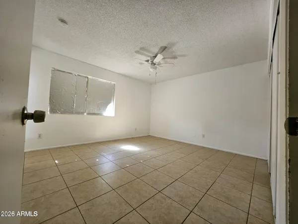 an empty room with windows and fan