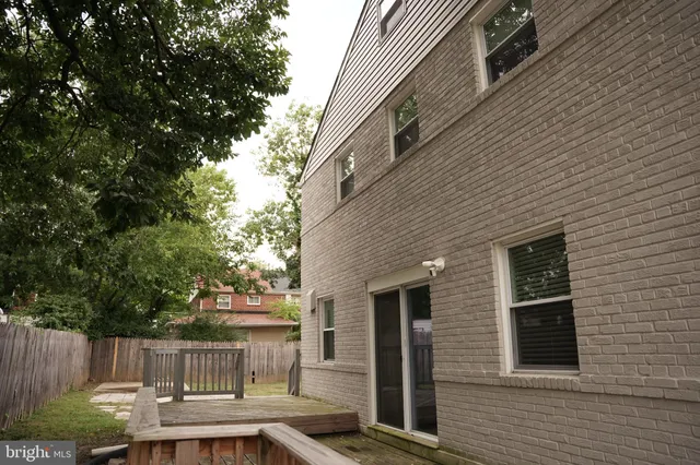 a view of backyard with barbeque grill and wooden fence