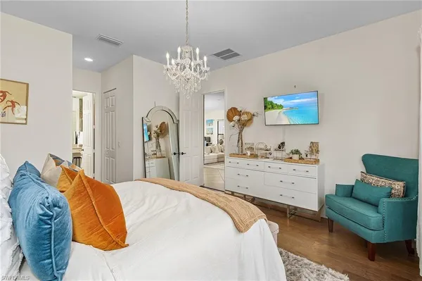 a bedroom with a bed chandelier and a window