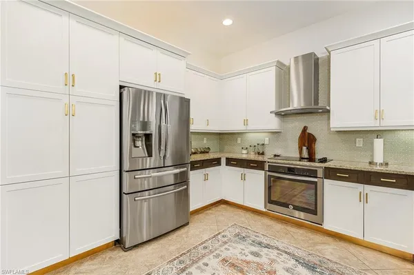 a kitchen with stainless steel appliances granite countertop a refrigerator and a stove top oven