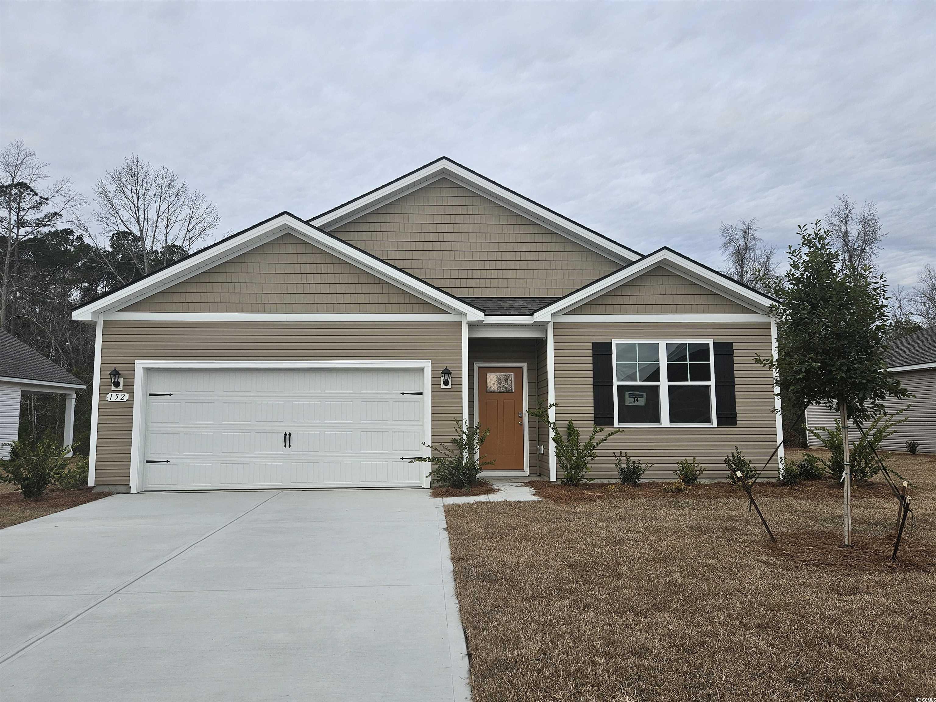 View of front of house with driveway, a garage, and a front yard