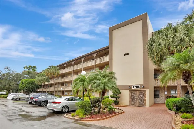 a view of a tennis ground with large trees
