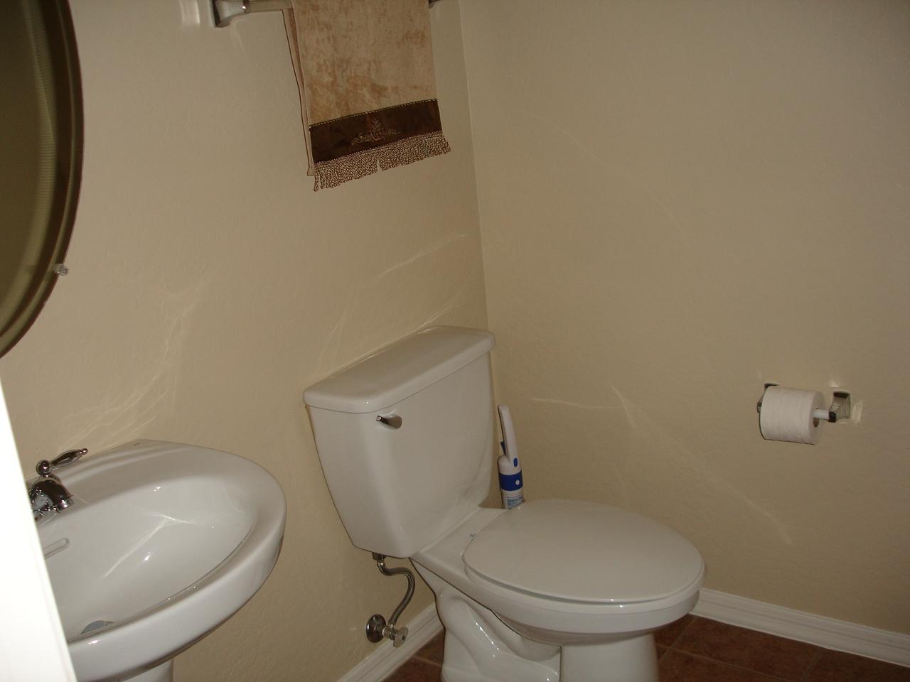 4744 East Timberline Road Gilbert, AZ 85297 - Photo 20 of 25 a white toilet sitting next to a bathroom sink and a mirror