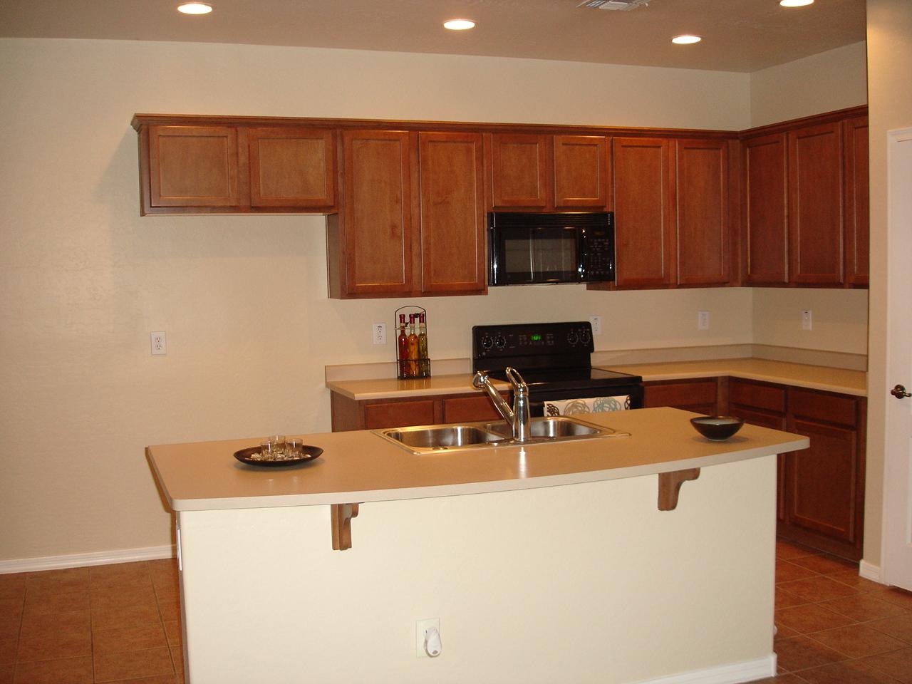 4744 East Timberline Road Gilbert, AZ 85297 - Photo 7 of 25 a kitchen with sink a microwave a stove and cabinets