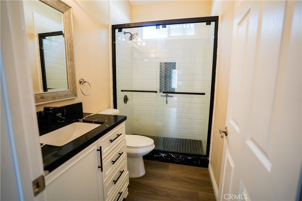 7562 Webster Street Highland, CA 92346 - Photo 19 of 30 a bathroom with a sink a toilet a mirror and shower