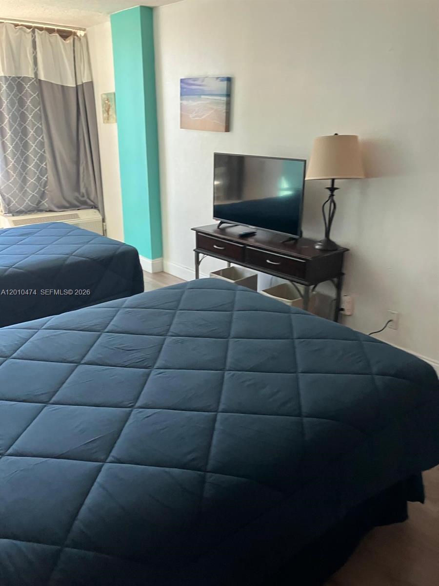 1909 South Atlantic Avenue, Unit 803804 Daytona Beach, FL 32118 - Photo 9 of 43 a bedroom with a bed and a flat screen tv