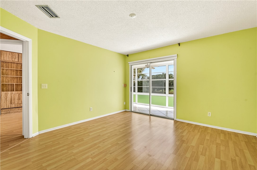 45 Vista Gdns Trail, Unit 202 Vero Beach, FL 32962 - Photo 16 of 32 a view of an empty room with wooden floor and a window