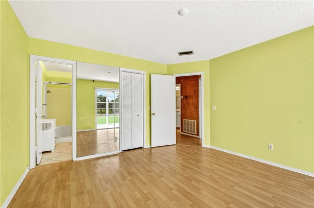 a view of a big room with wooden floor and windows