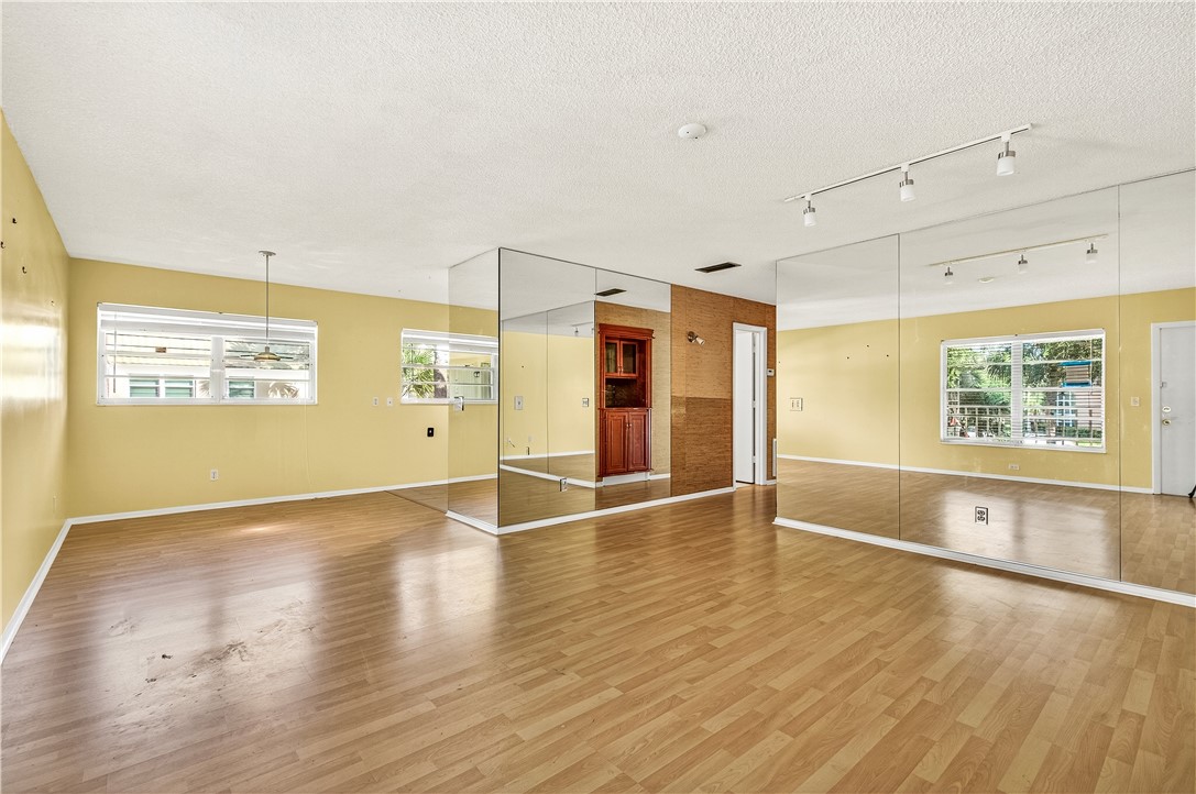 45 Vista Gdns Trail, Unit 202 Vero Beach, FL 32962 - Photo 3 of 32 an empty room with wooden floor and windows