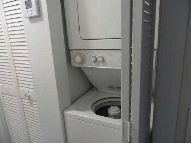 a view of swimming pool with a lawn chairs under palm trees