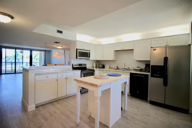 a view of a kitchen counter space a sink wooden floor and a window