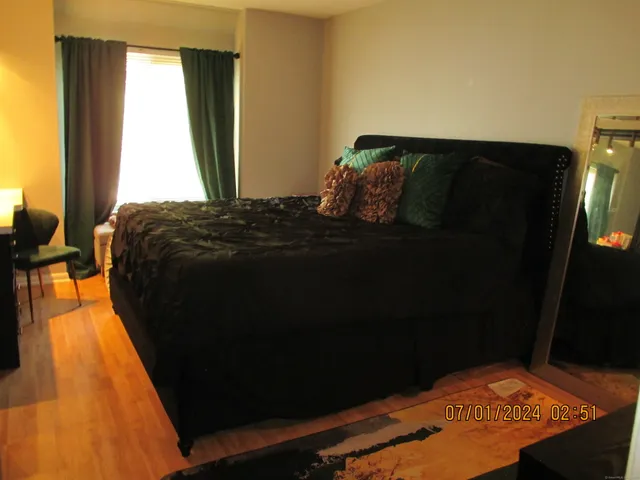 a bed sitting in a bedroom next to a window