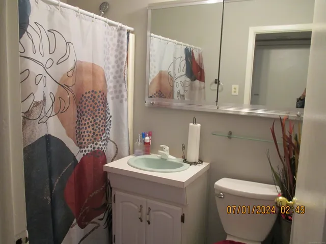a bathroom with a sink a toilet and a mirror