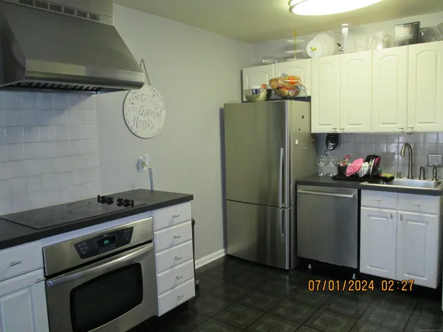 a kitchen with stainless steel appliances a stove a refrigerator and a microwave