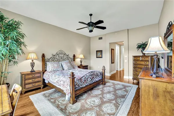 a bedroom with a bed a large window and potted plant