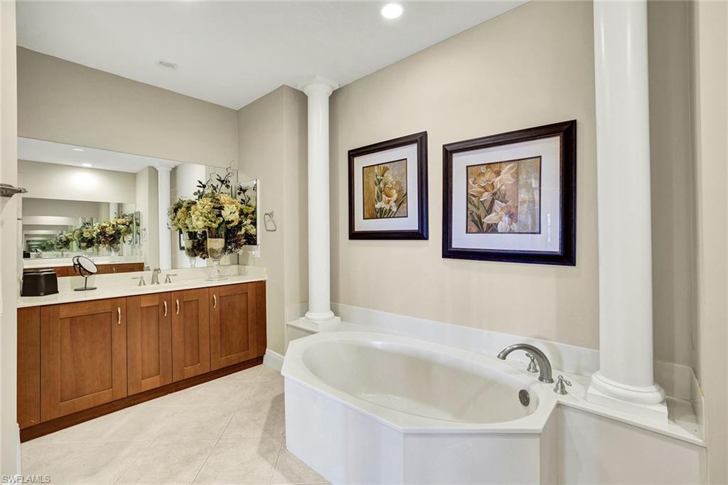 9234 Tesoro Lane, Unit 101 Naples, FL 34114 - Photo 16 of 25 a bathroom with a bathtub and mirror