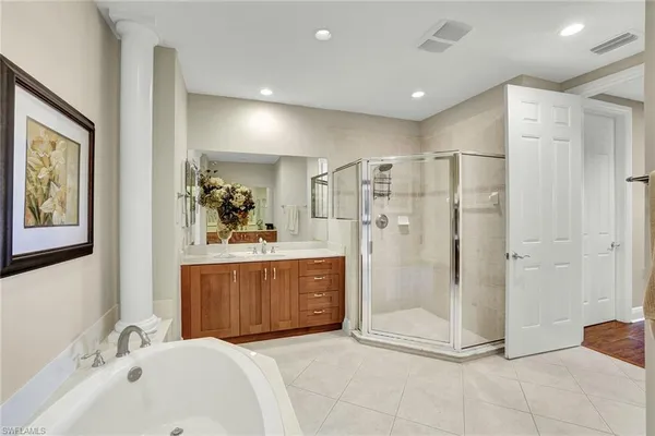 a bathroom with a tub a sink and mirror