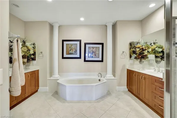a bathroom with a tub sink and mirror