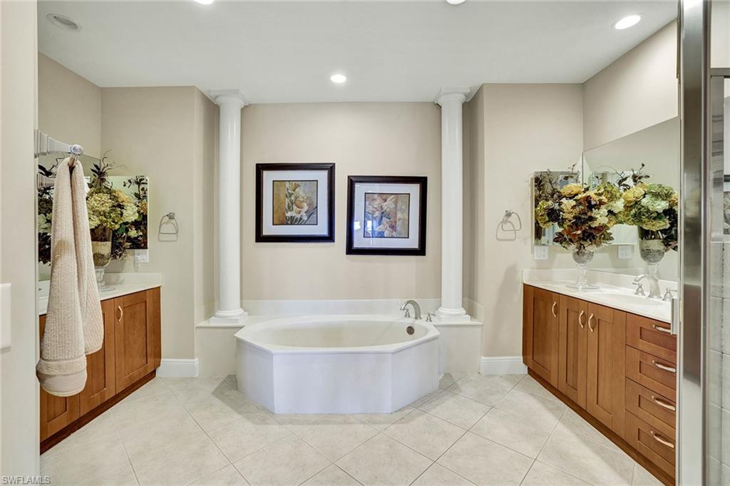 9234 Tesoro Lane, Unit 101 Naples, FL 34114 - Photo 18 of 25 a bathroom with a tub sink and mirror