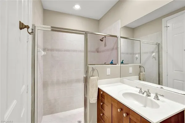 a bathroom with a sink shower and a mirror