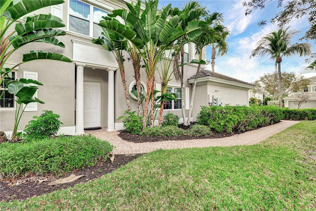 9234 Tesoro Lane, Unit 101 Naples, FL 34114 - Photo 5 of 25 a front view of a house with a garden