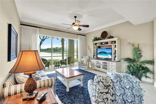 a living room with furniture a flat screen tv and a large window