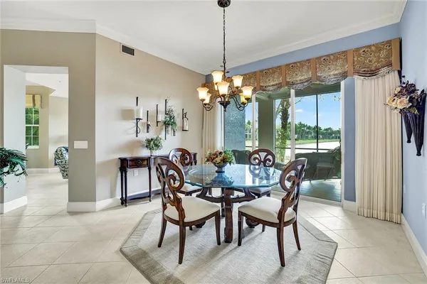 a dining room with furniture a chandelier and window