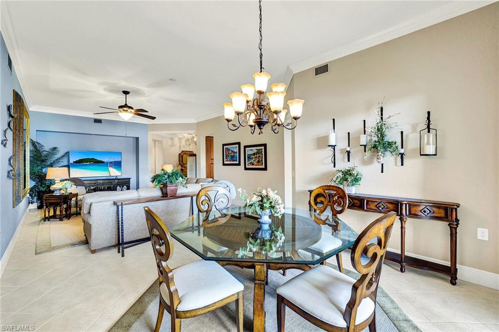9234 Tesoro Lane, Unit 101 Naples, FL 34114 - Photo 9 of 25 a dining room with furniture and chandelier