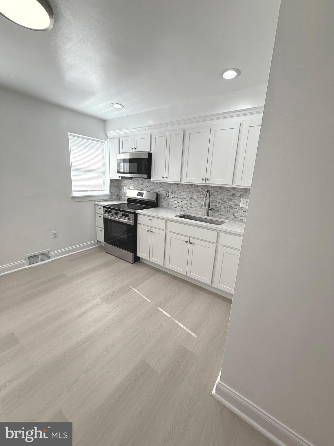 815 East Cold Spring Lane Baltimore, MD 21212 - Photo 11 of 43 a large kitchen with a stove a sink and a refrigerator