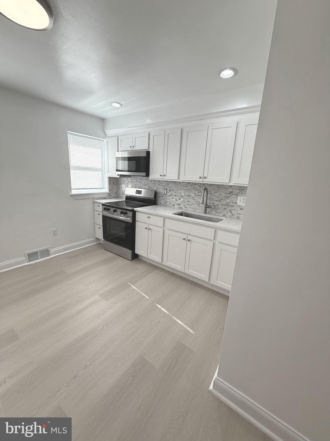 815 East Cold Spring Lane Baltimore, MD 21212 - Photo 12 of 43 a large kitchen with a stove a sink and a refrigerator