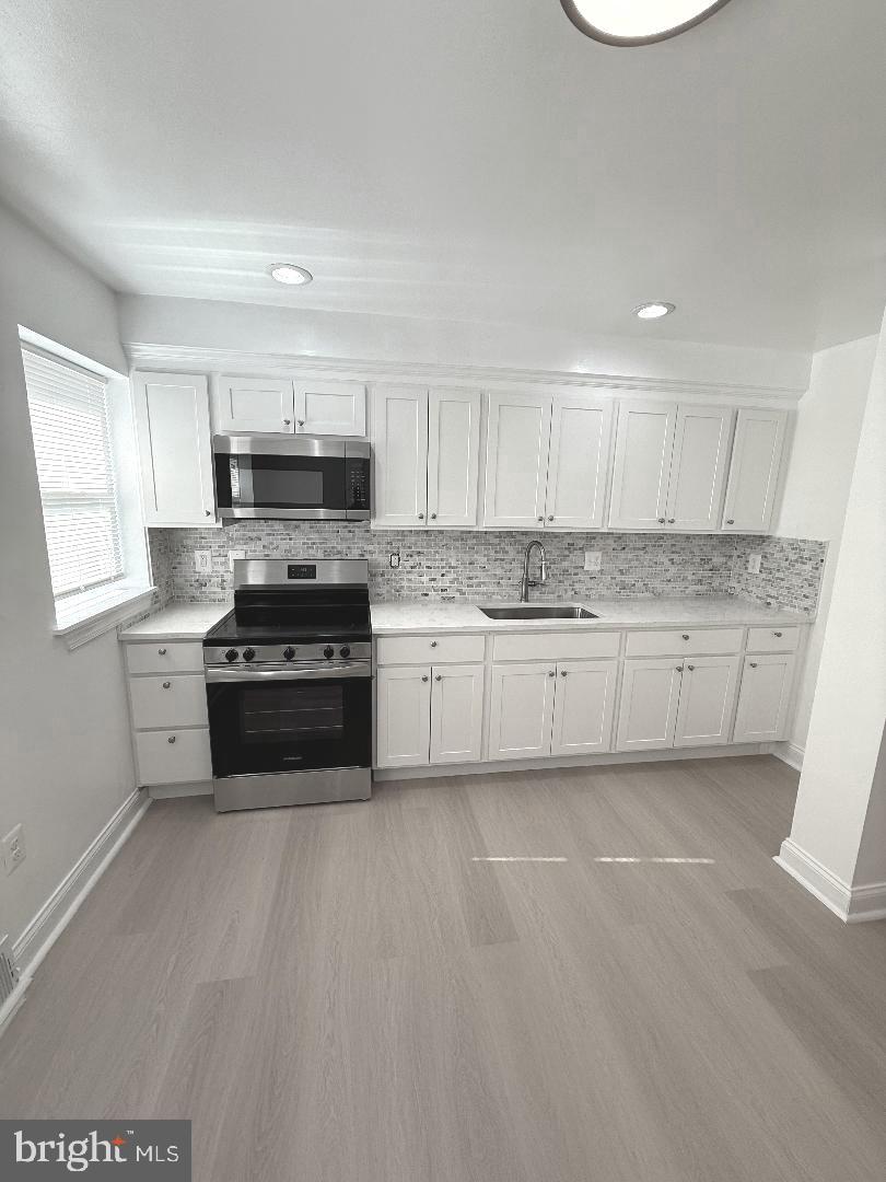 815 East Cold Spring Lane Baltimore, MD 21212 - Photo 13 of 43 a kitchen with stainless steel appliances a stove a sink a microwave a refrigerator and cabinets