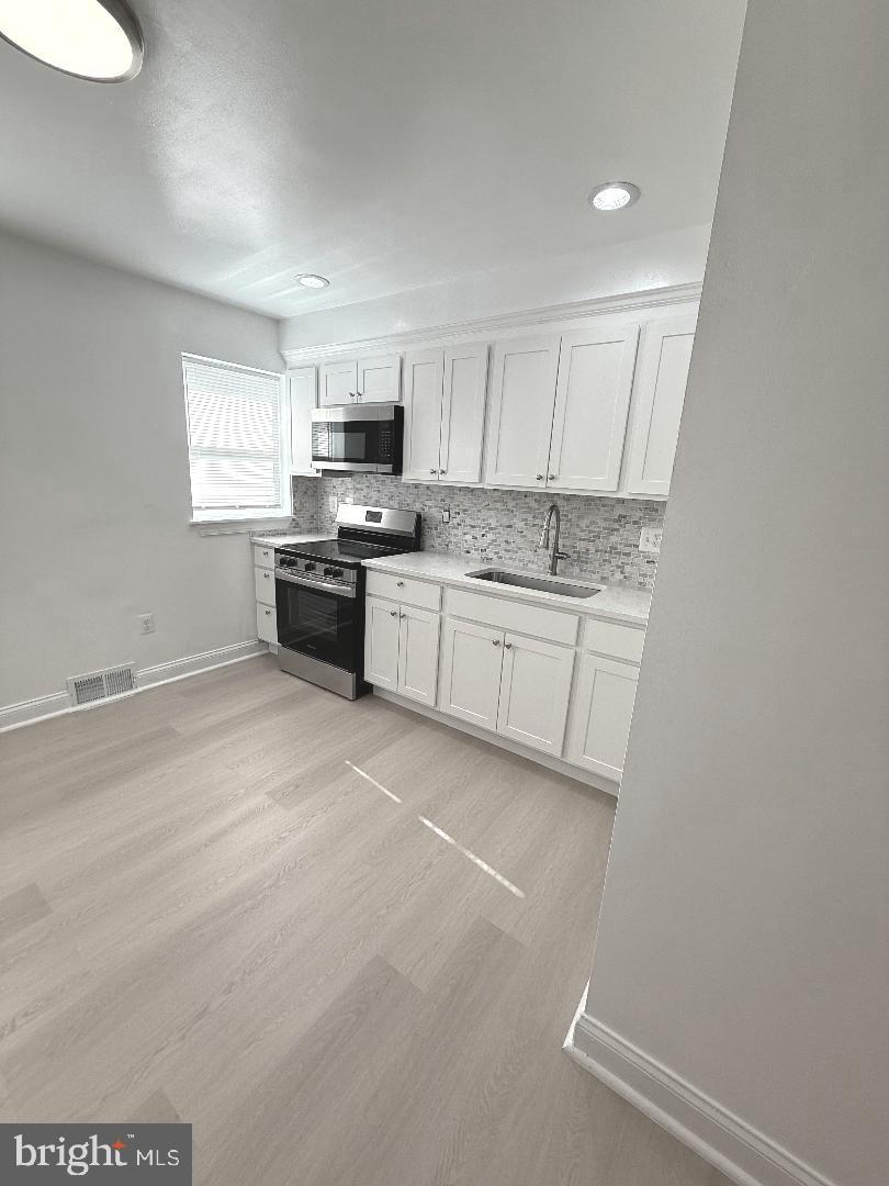 815 East Cold Spring Lane Baltimore, MD 21212 - Photo 10 of 43 a large kitchen with a stove a sink and a refrigerator
