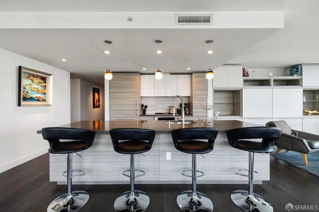 a kitchen with a refrigerator a stove a dining table and chairs