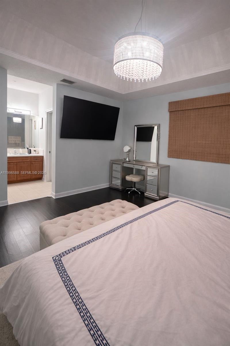 8441 Southwest 124th Avenue, Unit 106 Miami, FL 33183 - Photo 13 of 24 a bedroom with a bed and a flat tv screen on dresser