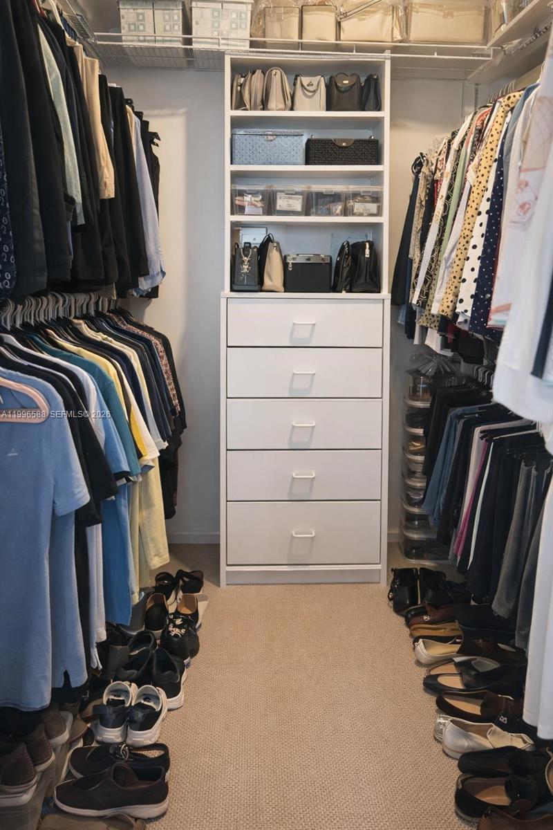 8441 Southwest 124th Avenue, Unit 106 Miami, FL 33183 - Photo 14 of 24 a view of walk in closet with clothes and shoes
