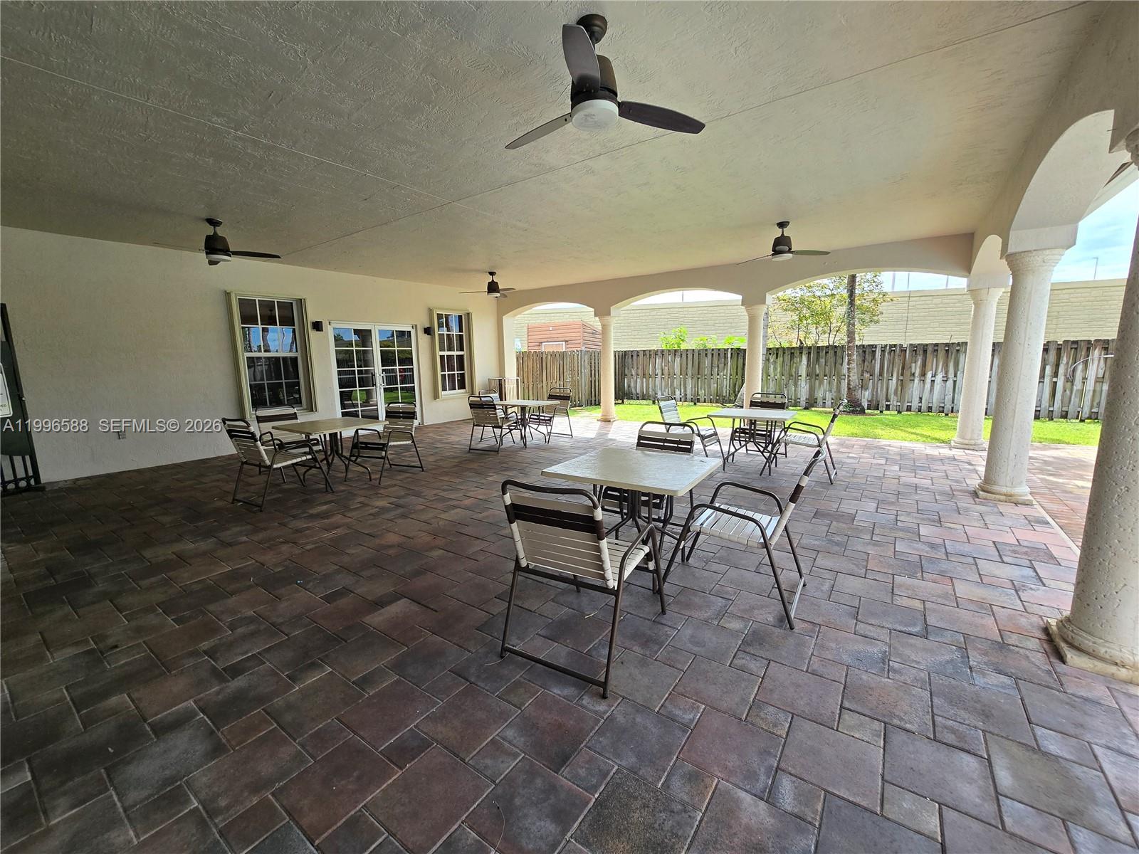 8441 Southwest 124th Avenue, Unit 106 Miami, FL 33183 - Photo 21 of 24 a room with lots of tables a chandelier and a dining table