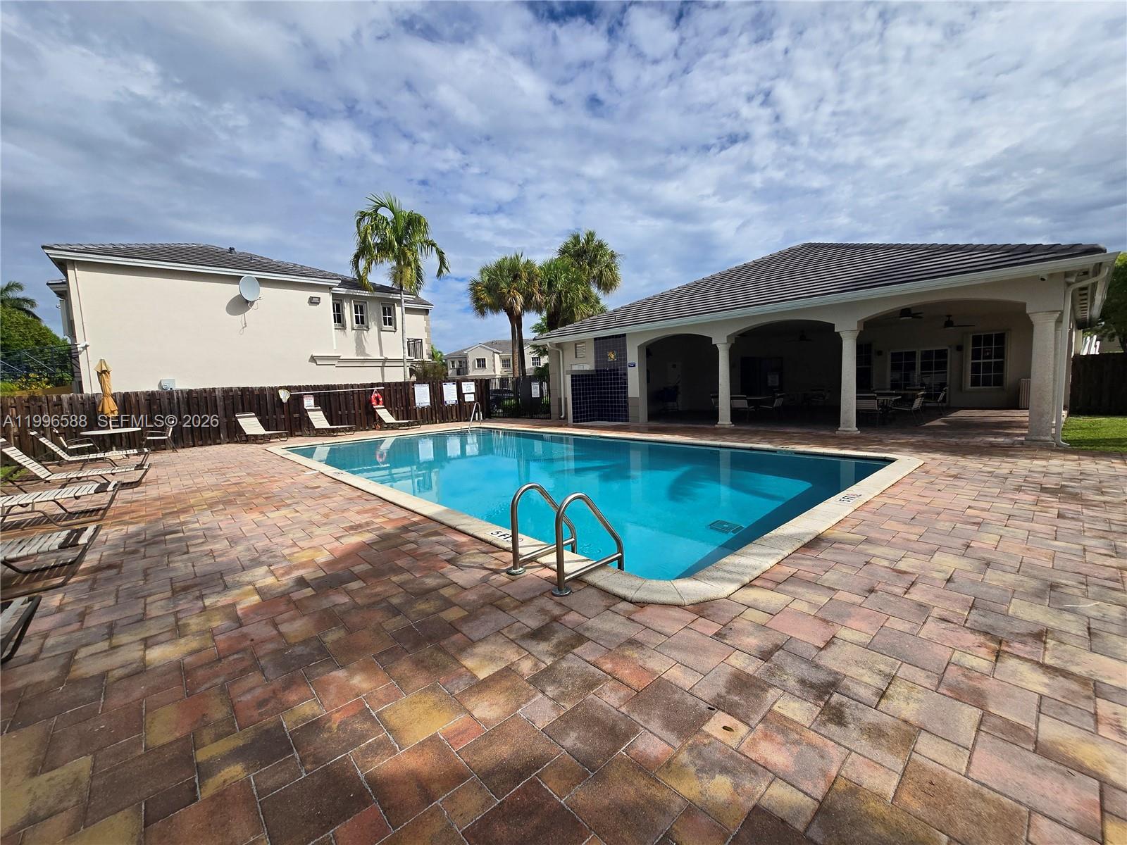 8441 Southwest 124th Avenue, Unit 106 Miami, FL 33183 - Photo 22 of 24 a view of a house with pool and sitting area