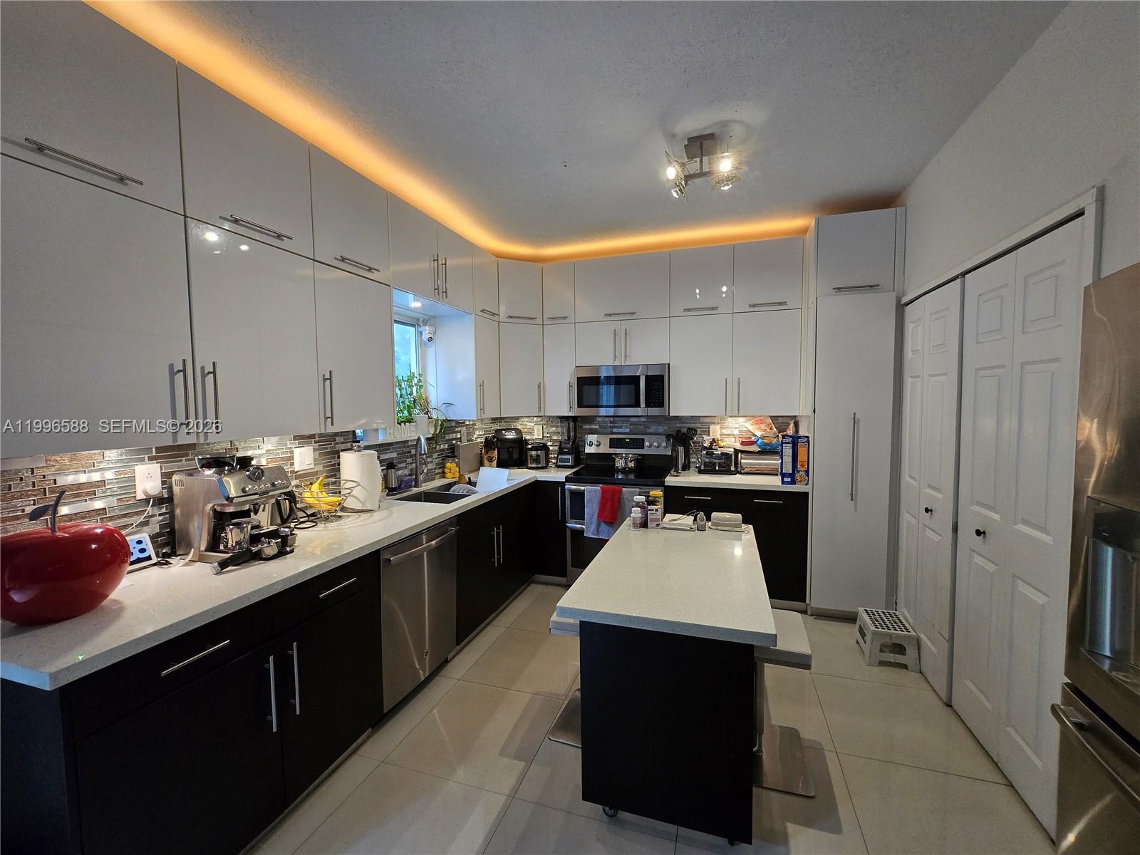 8441 Southwest 124th Avenue, Unit 106 Miami, FL 33183 - Photo 10 of 24 a kitchen with refrigerator and cabinets