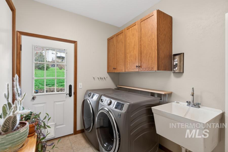 1933 Fletcher Place Moscow, ID 83843 - Photo 18 of 44 Laundry area featuring independent washer and dryer, cabinet space, and light tile patterned floors