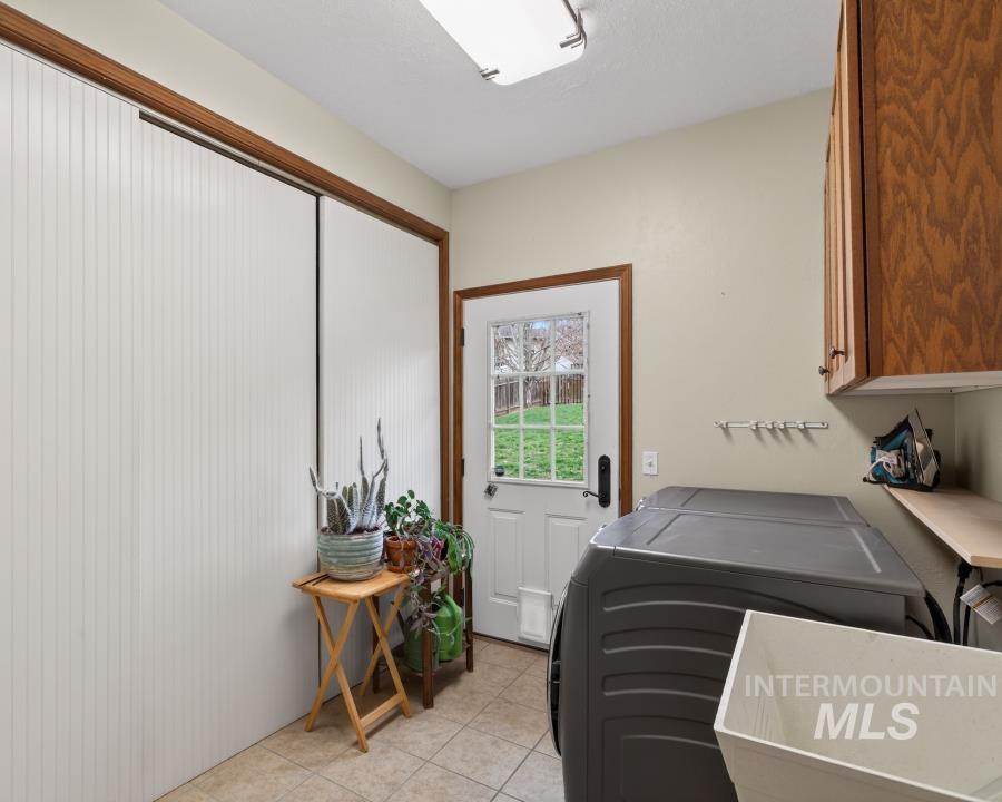 1933 Fletcher Place Moscow, ID 83843 - Photo 19 of 44 Laundry area featuring cabinet space, washing machine and dryer, and light tile patterned floors