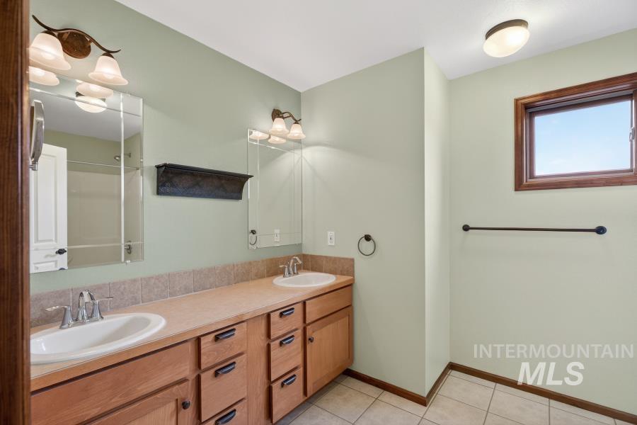 1933 Fletcher Place Moscow, ID 83843 - Photo 20 of 44 Bathroom with double vanity, a shower, and light tile patterned floors