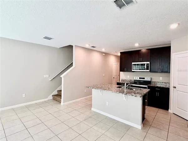 a kitchen with stainless steel appliances granite countertop a refrigerator a stove top oven a sink and dishwasher
