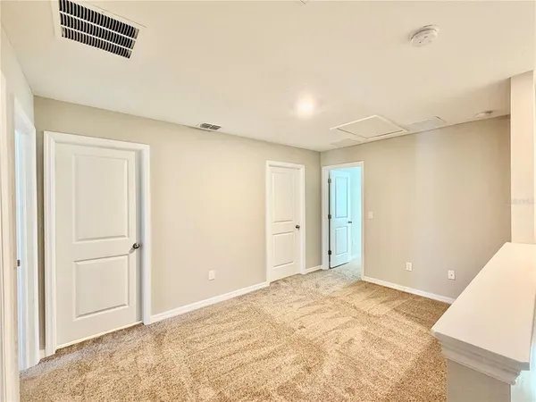 an empty room with a window and a ceiling fan