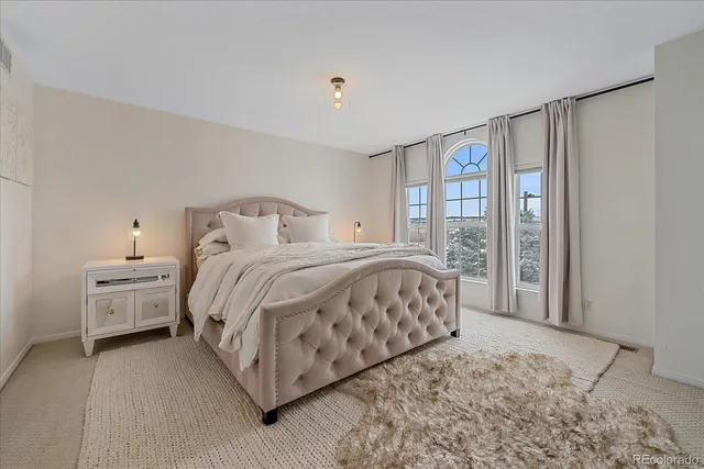 a bedroom with a large bed and a large window