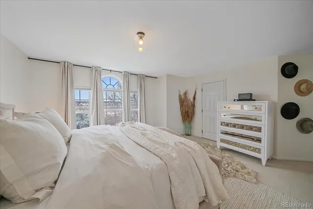 a bedroom with a bed and a large window