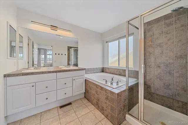 a spacious bathroom with a double vanity sink mirror and bathtub